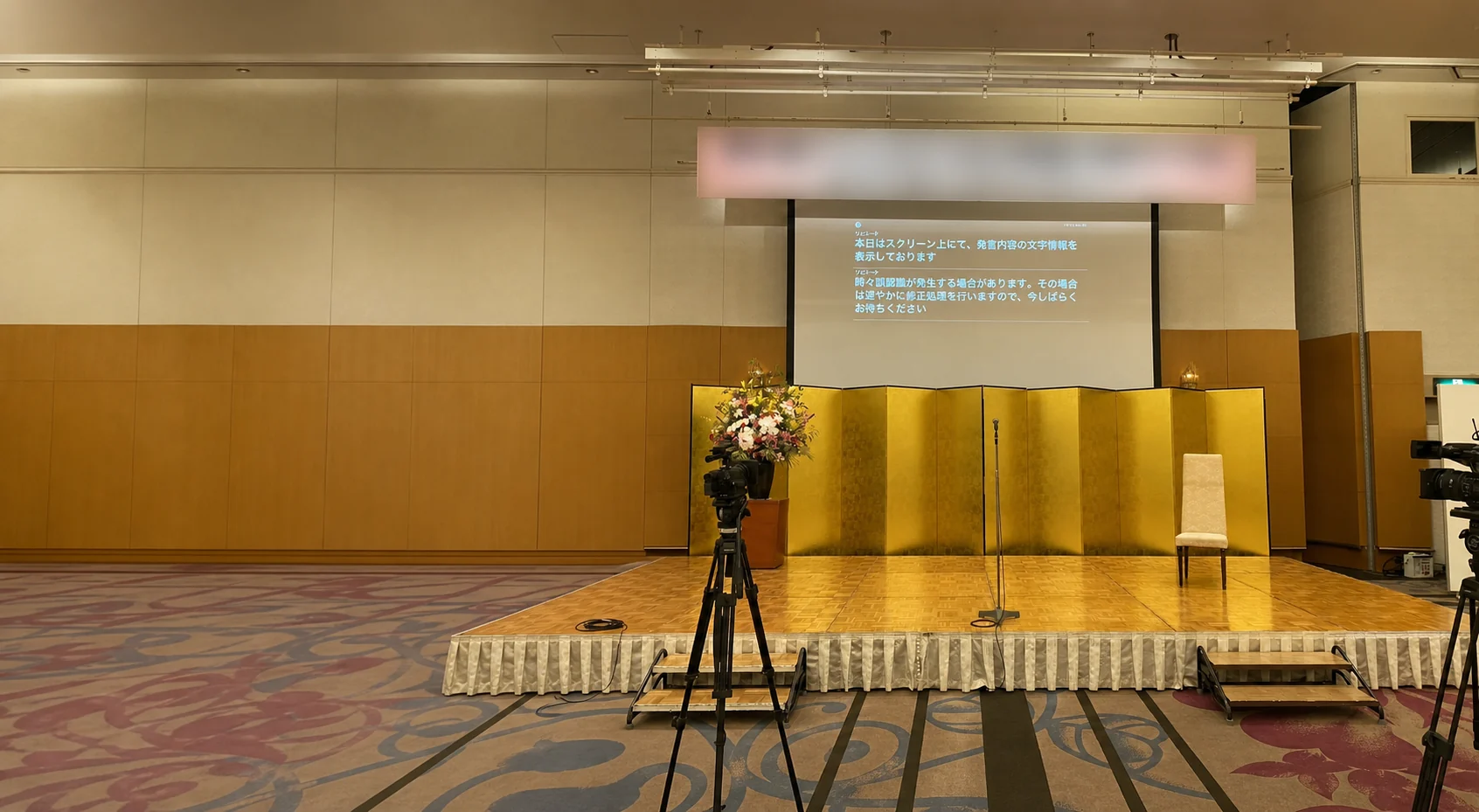 会場スクリーンにリアルタイム字幕を表示しているイベント会場