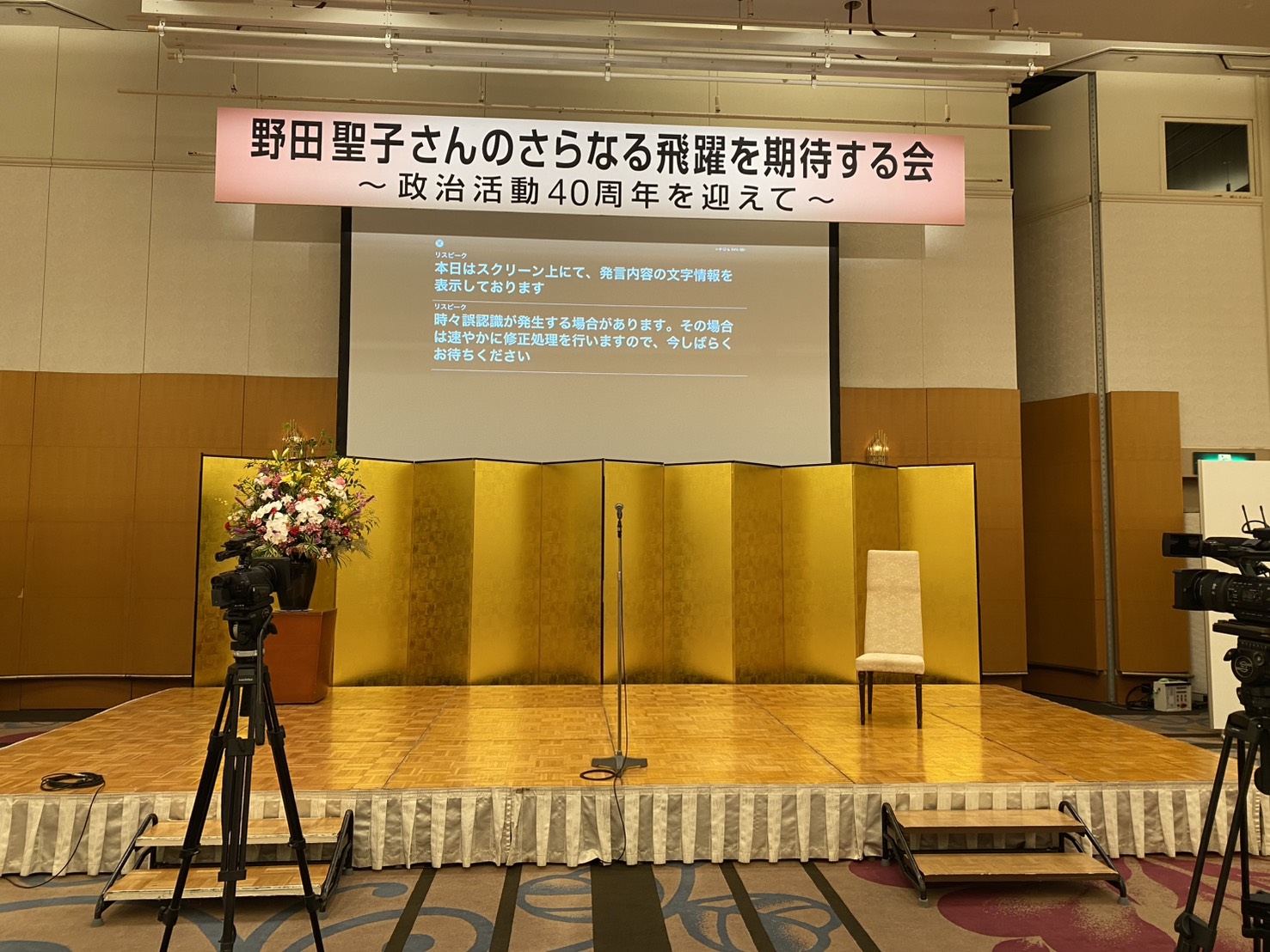 野田聖子さんのさらなる飛躍を期待する会の会場で字幕を表示している様子
